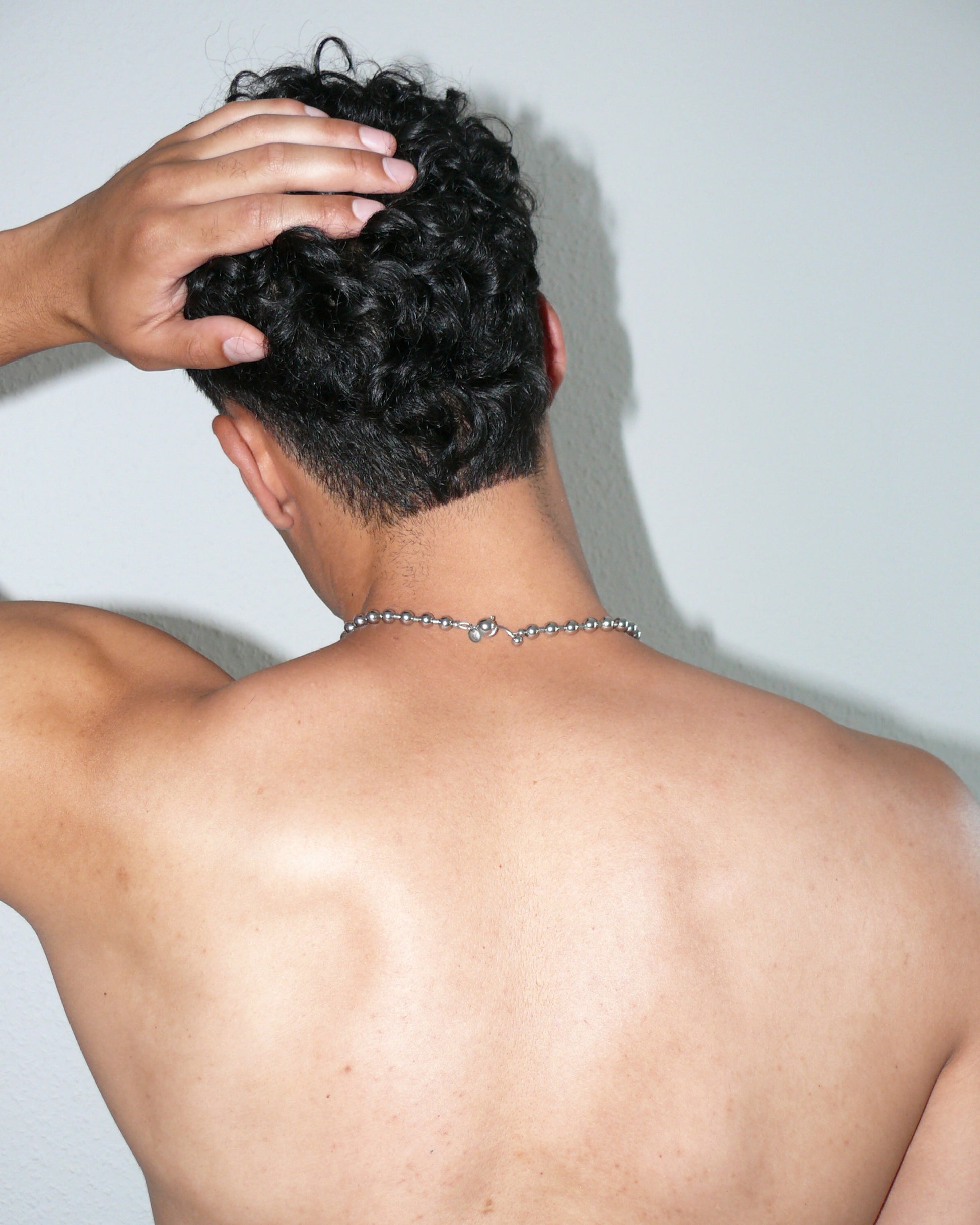 Steel ball chain necklace with piercing closure close up portrait on model back