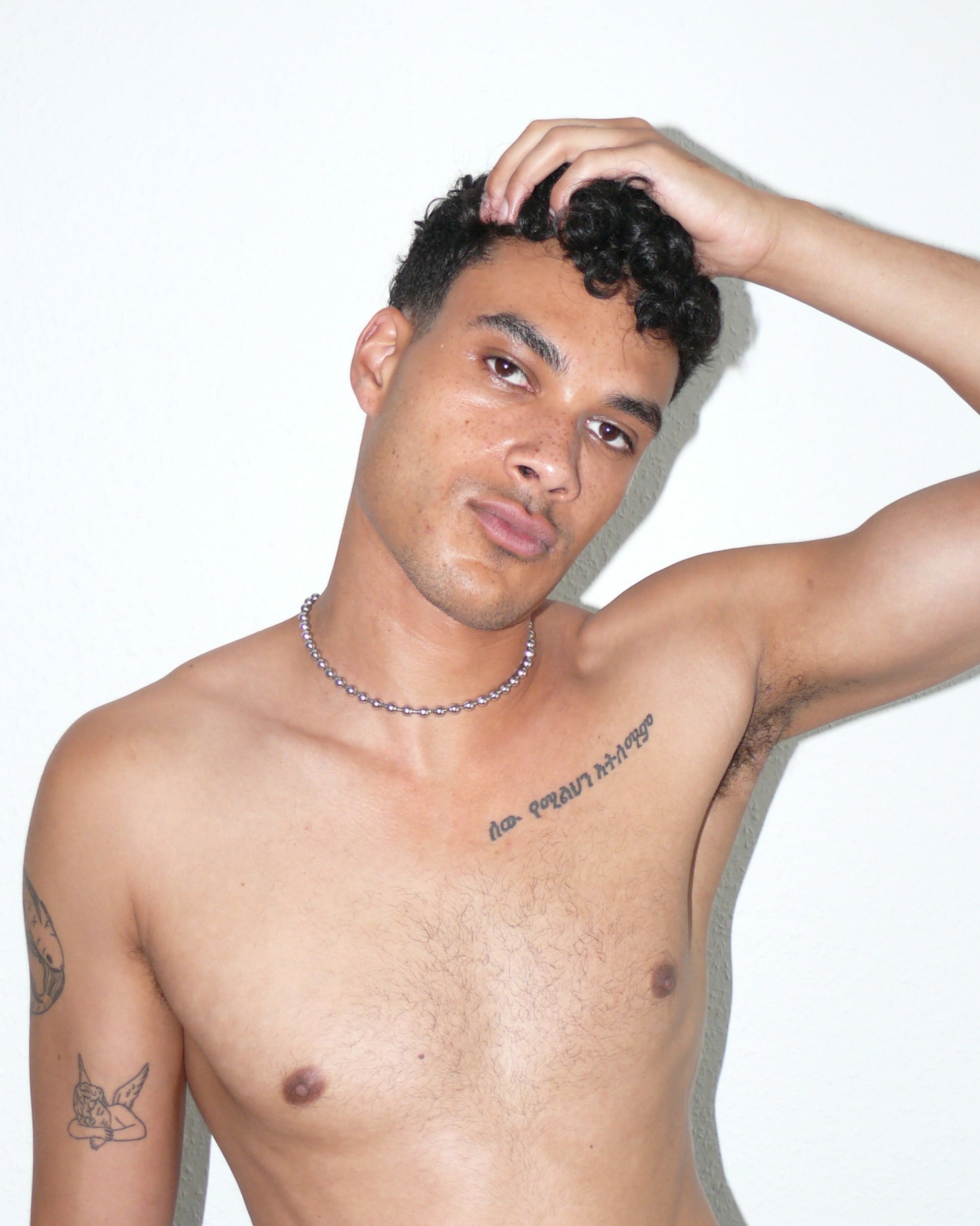 Steel ball chain necklace with piercing closure close up portrait on model holding head