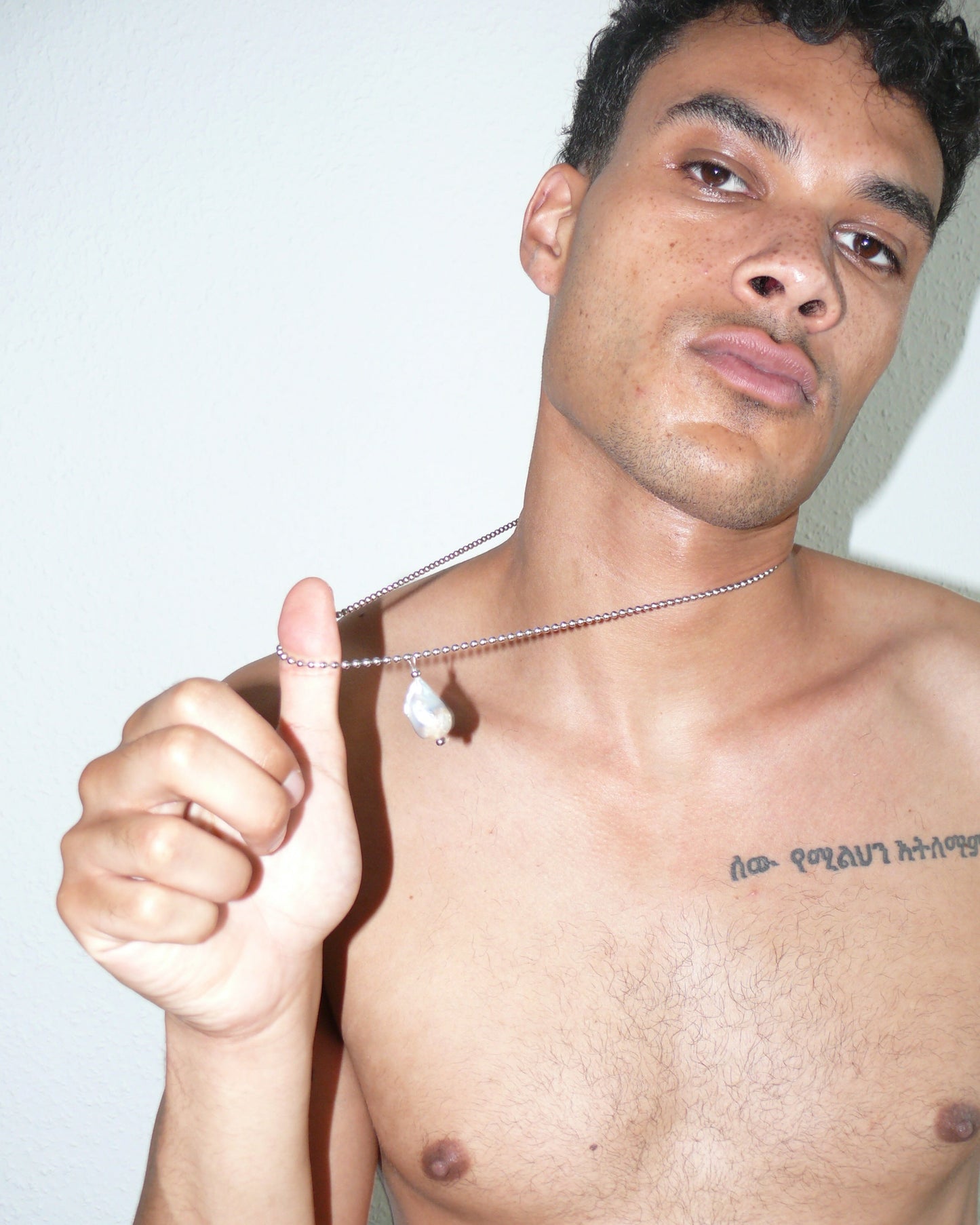 Steel ballchain with baroque pearl pendant close-up portrait on poc model