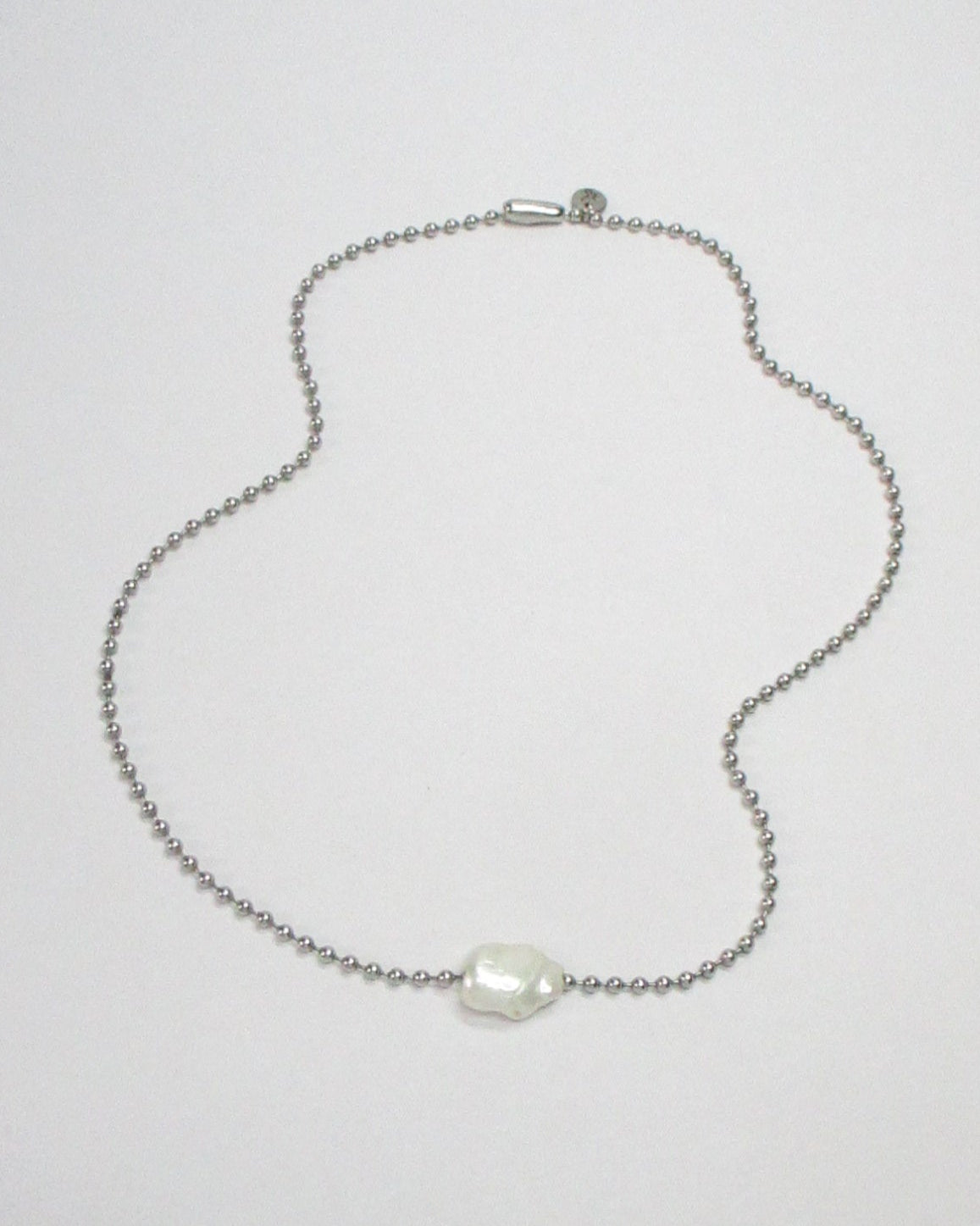 Steel ball chain with swinging pearl bead still fluid portrait