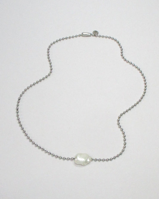 Steel ball chain with swinging pearl bead still fluid portrait