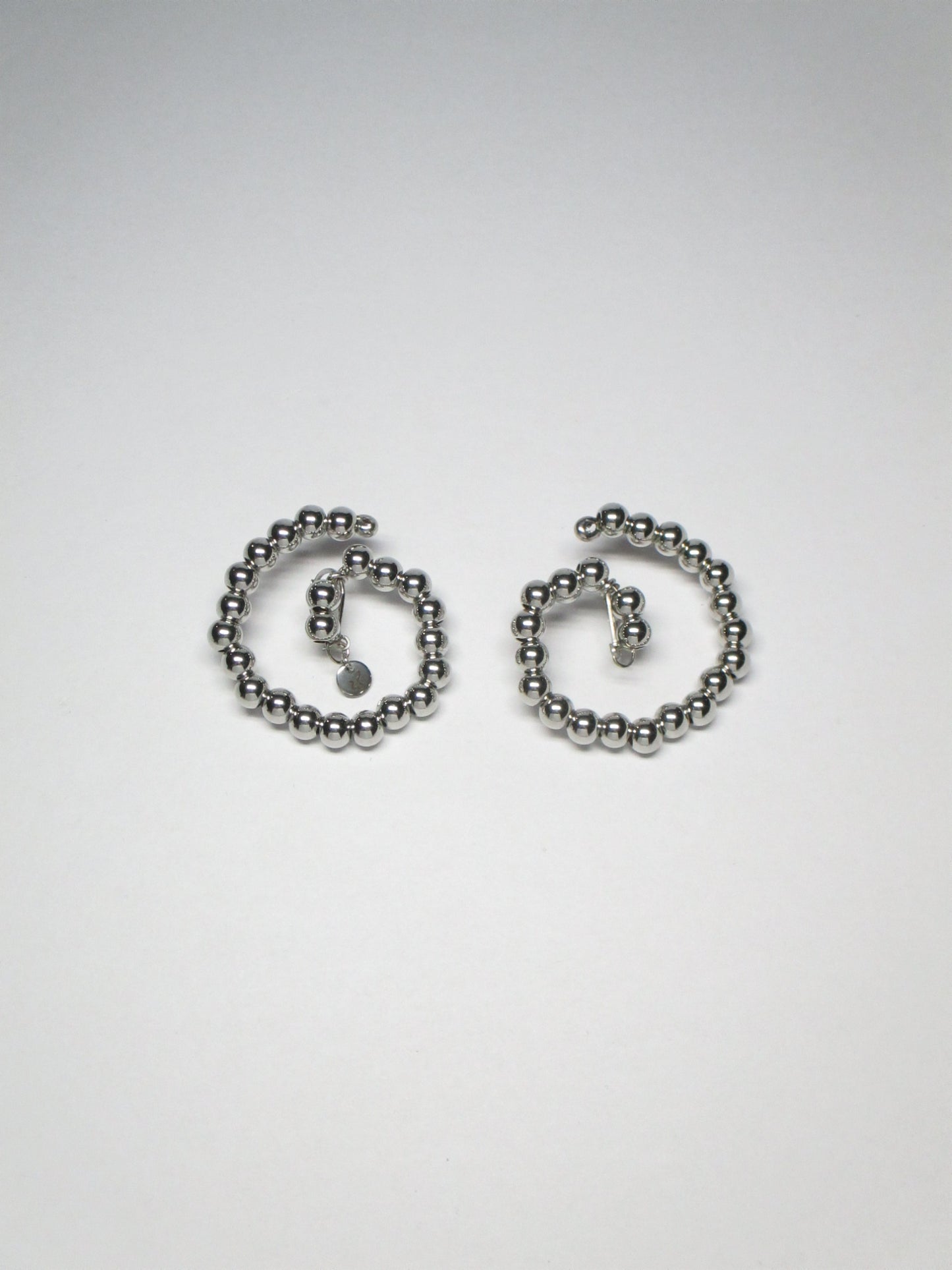 Steel beaded spiral button earrings still portrait