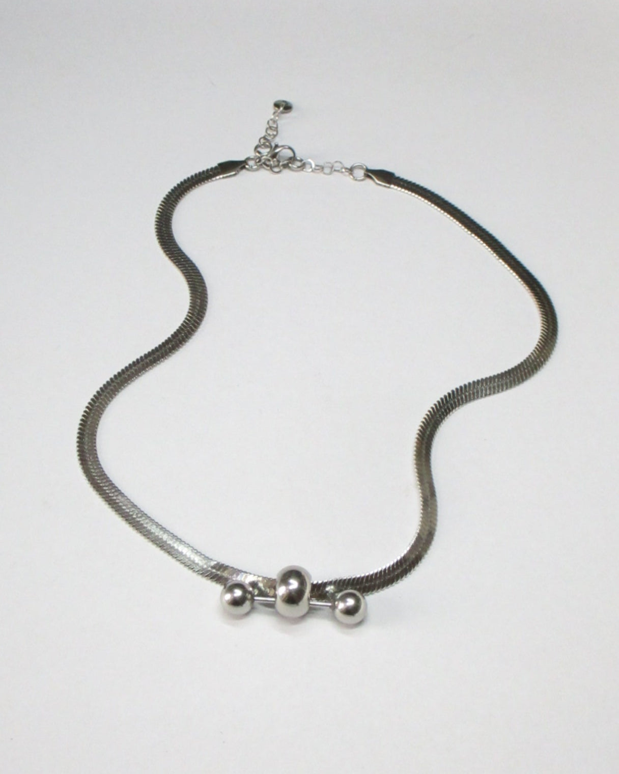 Steel flat chain necklace with central barbell piercing still fluid portrait