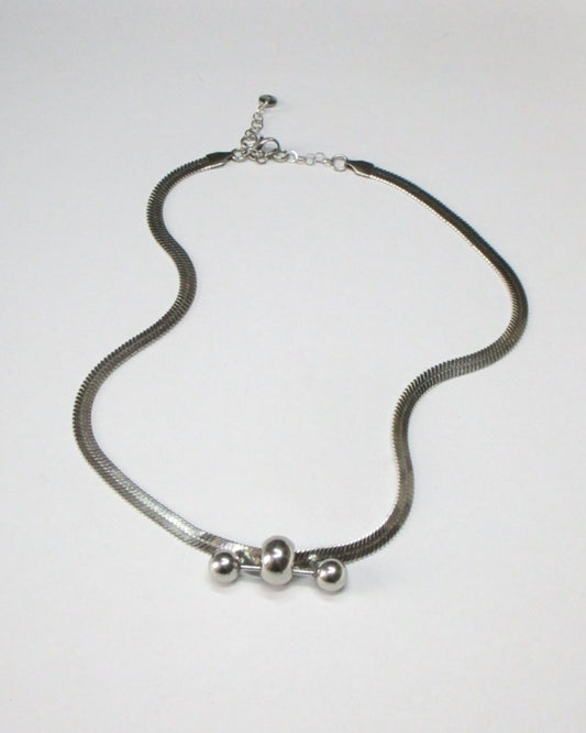 Steel flat chain necklace with central barbell piercing still fluid portrait