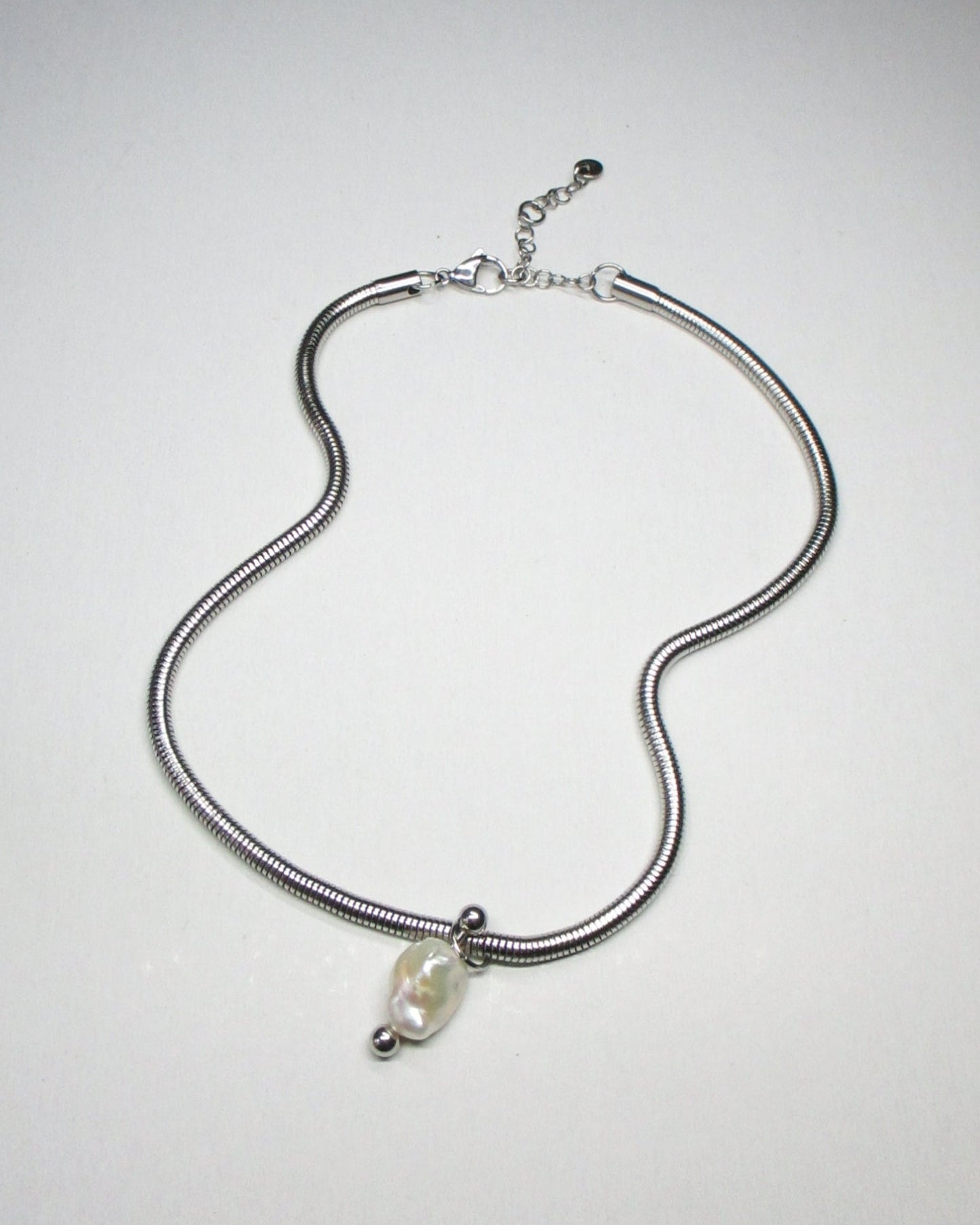 Steel snake chain with pearl pendant decorated with piercing still fluid portrait